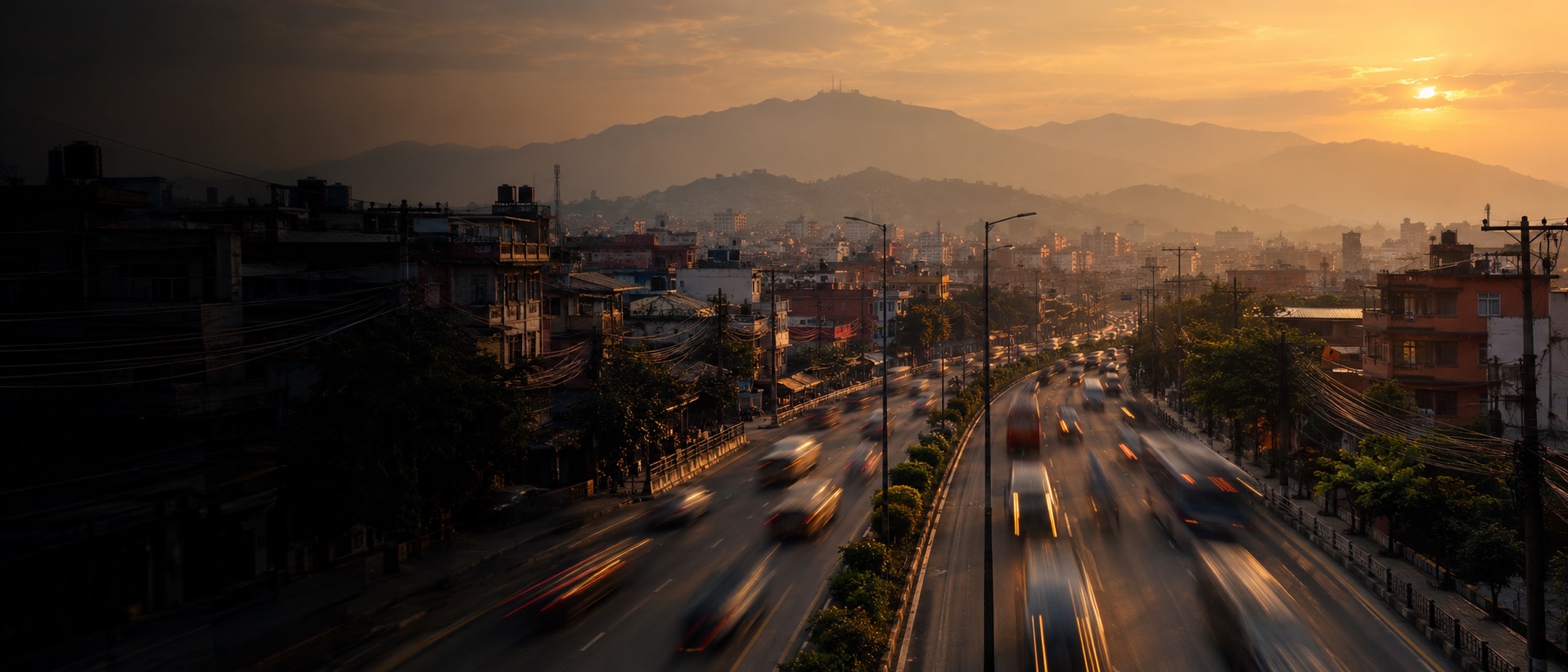 Evening traffic on a Kathmandu ring road, with the valley rim behind it